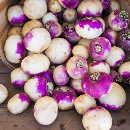 White turnips spilling out of a farmers basket.