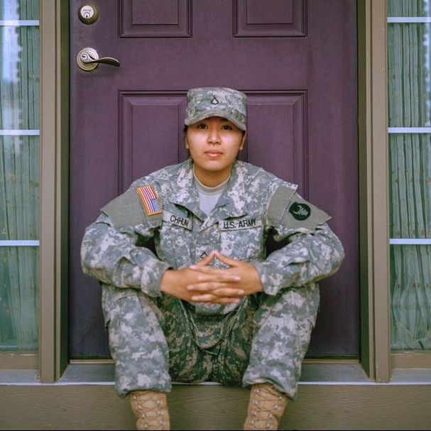 U.S. military personnel sitting on door step.