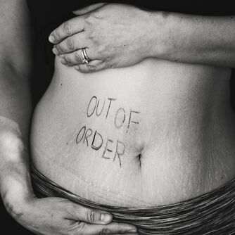 Picture of someone's stomach with the words 'out of order' writen on it.