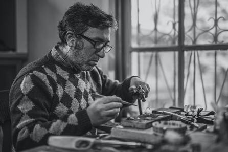 Man sitting at a desk working on a hobby.